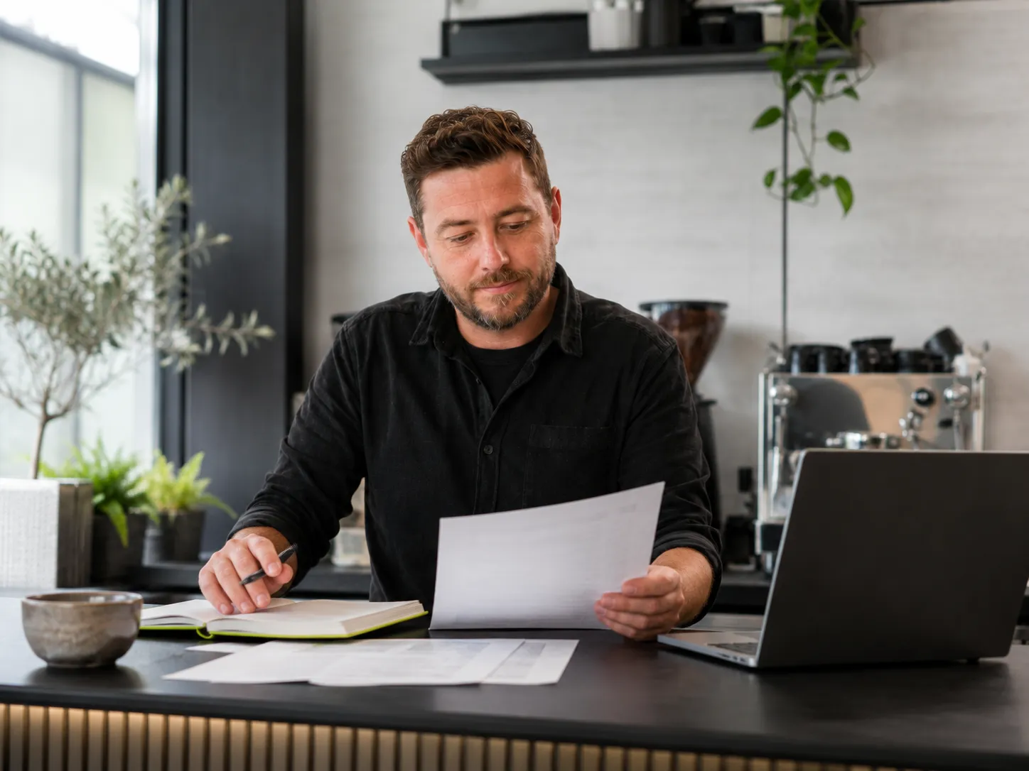 UK business owner reviewing supplier paperwork and invoices