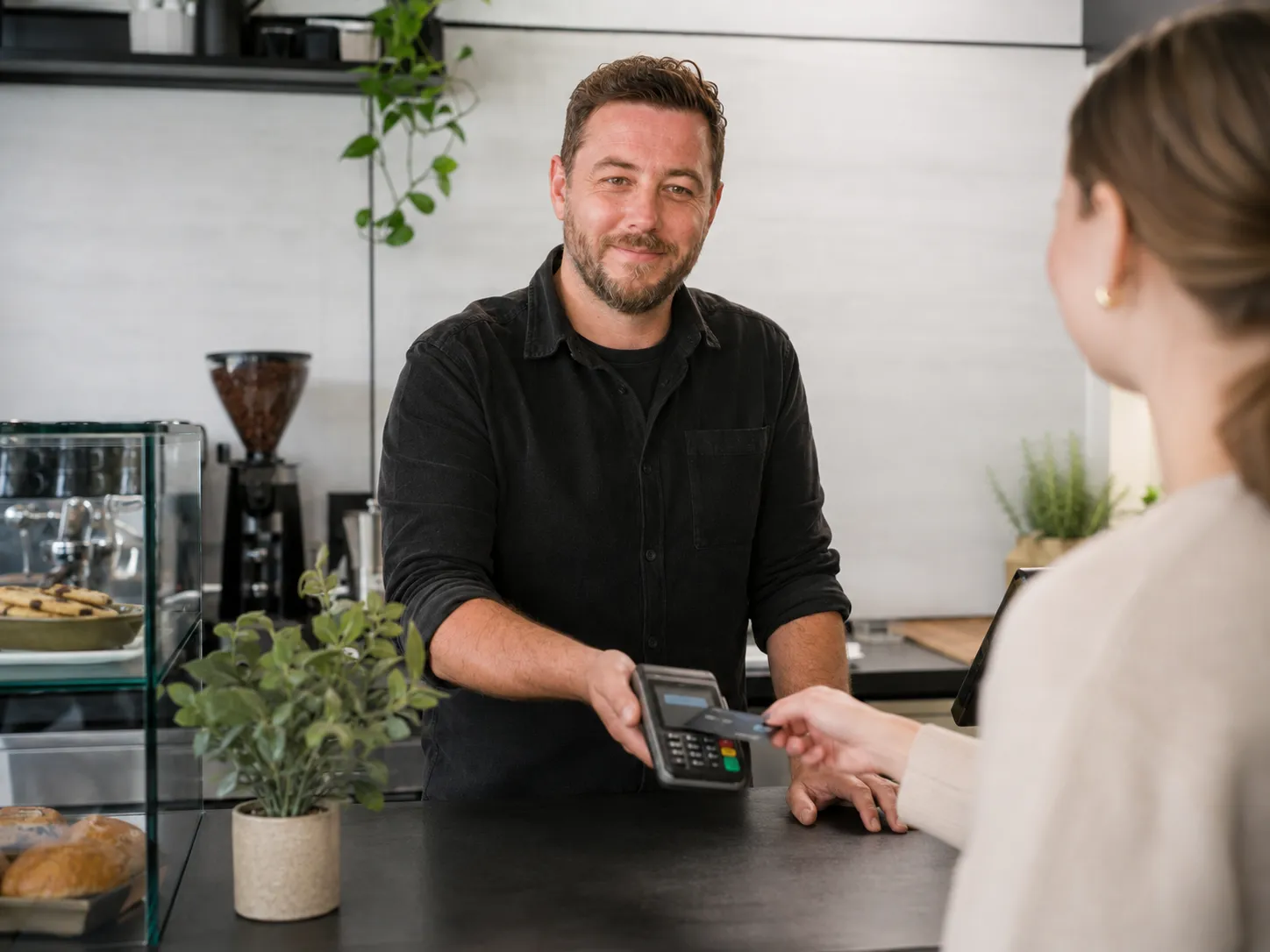 UK business owner taking a card payment at the counter